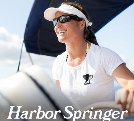 Harbor Springs Michigan inspired brand, Harbor Springer dog logo on a white womens t-shirt worn by a woman sailing.