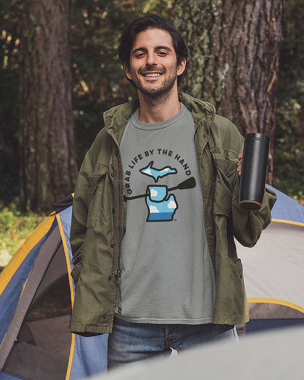 Camping man wearing a Michigan tee for people who kayak, canoe or paddleboard, showing the state of Michigan grabbing a paddle with the slogan Grab Life by the Hand™.