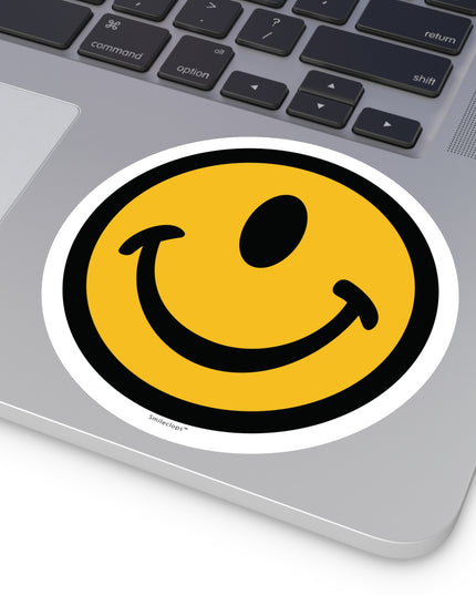 Extra large one-eyed smile face round sticker by the Smileclops™ brand on a laptop.