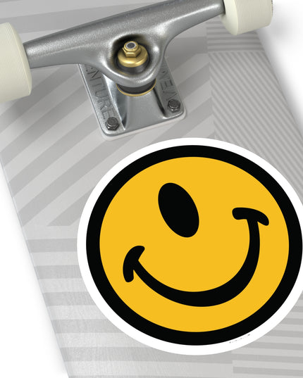 Jumbo one-eyed smile face round sticker by the Smileclops™ brand on a skateboard.