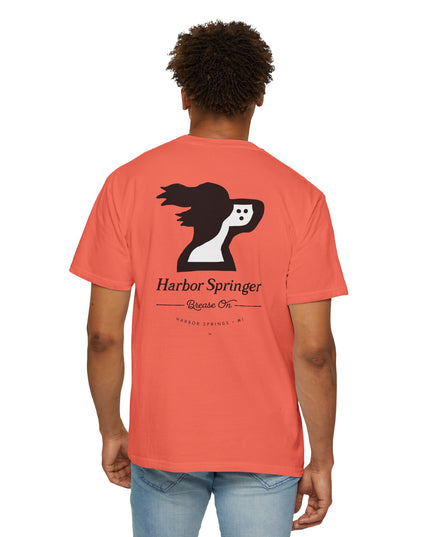 Standing man wearing salmon color t-shirt by the Harbor Springer brand with a springer spaniel dog logo and Brease On tagline on the back.