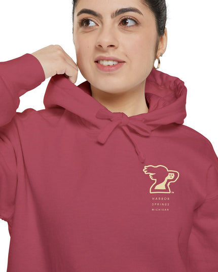 Woman wearing red color hoodie by the Harbor Springer brand with a springer spaniel dog logo and Harbor Springs Michigan text.
