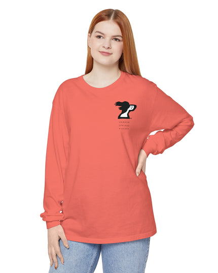 Woman wearing a salmon colored long sleeve t-shirt by the Harbor Springer brand with a springer spaniel dog logo and Harbor Springs Michigan text.
