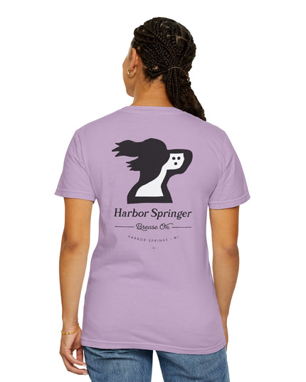 Woman wearing purple color t-shirt by the Harbor Springer brand with a springer spaniel dog logo and Brease On tagline on the back.